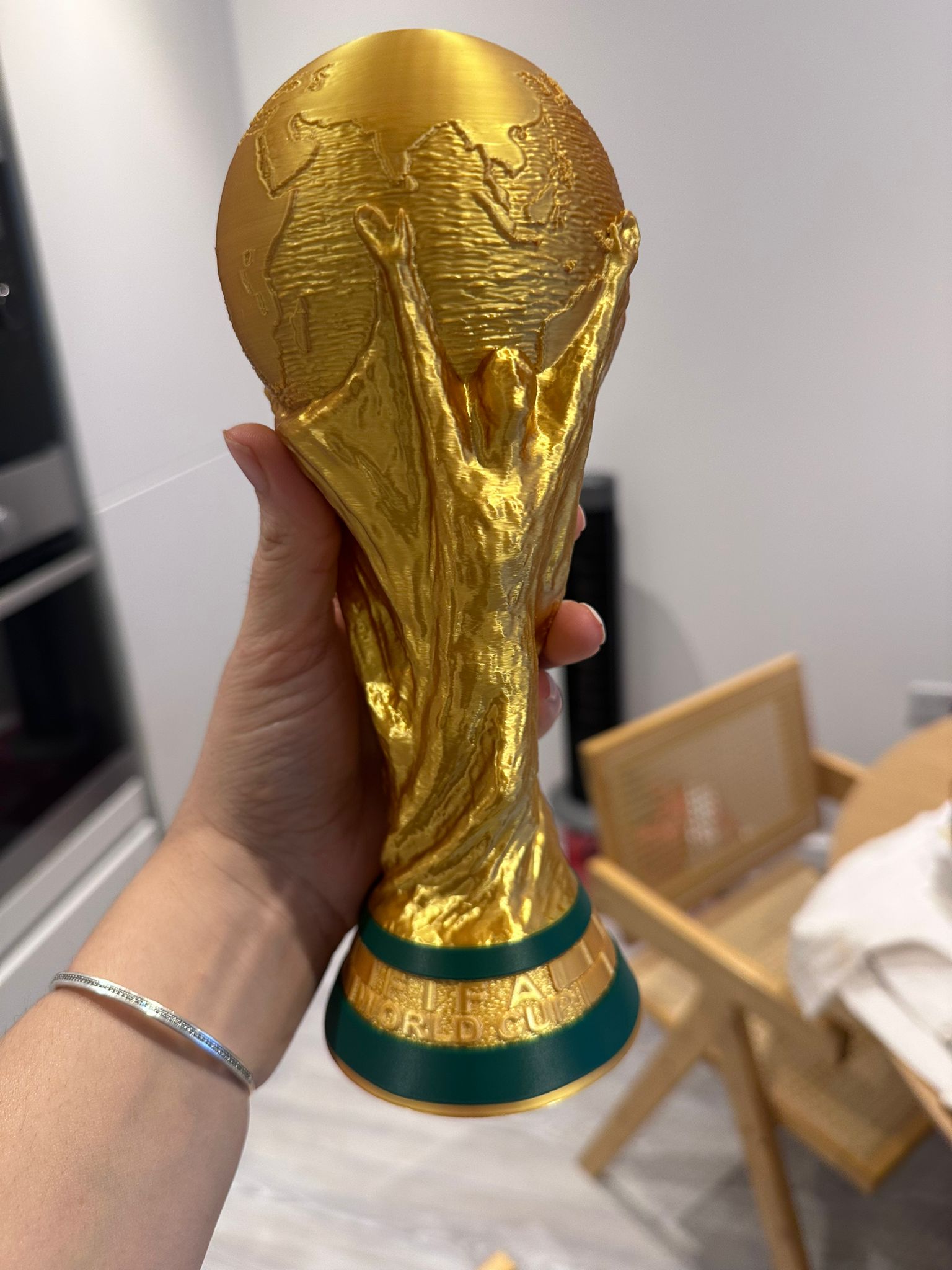 The real gold World Cup trophy replica held in the hand